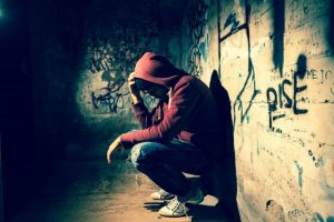 Homeless-boy-on-graffiti-wall